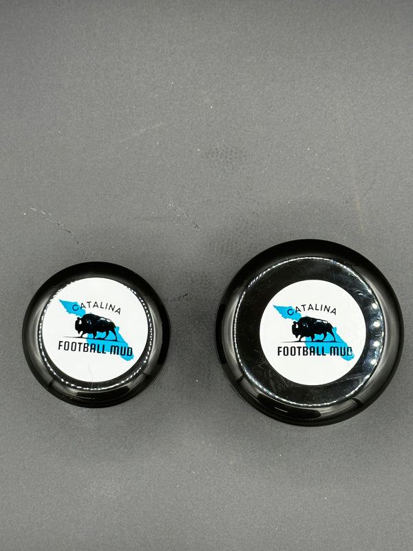 Two black bottle caps with white labels on a gray background